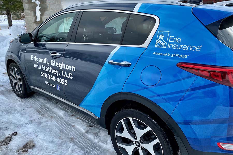 About Our Agency - Closeup View of an SUV Parked in the Snow with Brigandi Glefhorn & Haffley Branding and Erie Insurance Logo